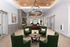 Elegant lobby showcasing modern design with chic green armchairs, stylish chandelier, and a welcoming atmosphere.