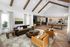 Luxurious open-plan living room with high vaulted ceilings, modern kitchen, and stylish decor, perfect for entertaining.