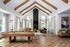 Luxurious living room with high vaulted ceilings, elegant wooden beams, and a chic pool table, perfect for entertainment and relaxation.