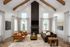 Stunning living room with vaulted ceilings, exposed wooden beams, cozy fireplace, and elegant modern furnishings.