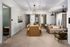 Elegant living space featuring a cozy sofa, modern dining area with a wooden table, and natural light streaming through large windows.