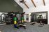 Modern fitness center with state-of-the-art gym equipment, featuring weight racks and workout benches under stylish vaulted ceilings.