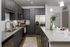 Elegant modern kitchen with sleek dark cabinetry, granite countertops, stainless steel appliances, and stylish pendant lighting.