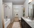 Elegant bathroom with granite countertops, modern fixtures, and a spacious walk-in closet.
