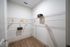 Spacious walk-in closet featuring modern shelving and wooden hangers, perfect for organized storage.
