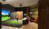 Luxury apartment game room with a digital golf simulator, cozy seating, and stylish decor for a modern lifestyle.