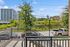 Inviting balcony view overlooking lush greenery and modern office buildings, ideal for urban living.