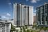 Modern high-rise apartment building with sleek glass facade, surrounded by lush greenery and urban skyline views.