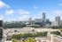 Captivating city skyline view with modern skyscrapers and lush greenery under a bright blue sky.