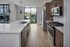Modern kitchen with sleek stainless steel appliances, elegant wood cabinetry, and stunning garden view from large windows.