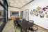 Sleek contemporary meeting room featuring a large wooden table, modern chairs, vibrant abstract wall art, and floor-to-ceiling windows.
