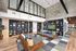 Modern living space featuring cozy wooden swing seating, stylish shelves with decor, and a sleek, open layout with chic lighting.
