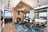 Sleek modern living room with panoramic city views, featuring elegant wood paneling, plush furniture, and cozy fireplace lighting.
