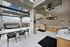 Modern outdoor terrace with sleek seating, ambient string lights, and a fully-equipped BBQ area, offering scenic views under a spacious pergola.