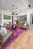 Chic and contemporary living room featuring stylish furniture, a vibrant magenta rug, and modern lighting with a built-in TV.
