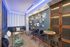 Chic and cozy lounge area with modern lighting, stylish wall art, comfortable seating, and elegant bar stools, perfect for relaxation.