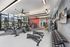 Modern fitness center with large windows, cardio machines, and weightlifting equipment, offering a vibrant workout environment.
