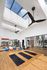 Bright and airy gym with skylights, yoga mats, exercise balls, and modern equipment on polished hardwood floors.
