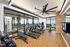 Modern fitness room with panoramic city views, featuring high-tech treadmills and a sleek design.