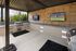 Chic outdoor kitchen setup with sleek stainless steel grill, modern flat-screen TVs, and lush green views.