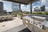 Modern rooftop patio with sleek outdoor kitchen, stylish dining area, and stunning city views.