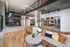Modern loft-style space with sleek spiral staircase, open seating area, and stylish decor.
