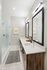 Modern bathroom with sleek double vanity, frameless glass shower, and elegant lighting.