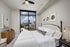 Luxurious bedroom with a breathtaking cityscape view, featuring elegant decor and modern furnishings, perfect for urban living.