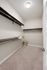 Spacious walk-in closet with elegant shelving and modern lighting, offering ample storage and organization potential.