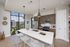 Modern kitchen interior with sleek appliances, wooden cabinetry, and large windows offering a stunning city view.