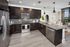 Modern kitchen with sleek dark wood cabinetry, stainless steel appliances, and a stylish open-concept design overlooking a cozy living area with large windows.