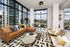 Stunning modern living room with floor-to-ceiling windows, featuring a luxurious leather sofa and chic decor with city views.