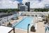 Elegant rooftop pool with chic cabanas and plush lounge chairs offering stunning city views.