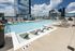 Luxurious rooftop pool area with sleek loungers and panoramic city views, perfect for relaxation and leisure.