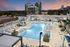 Luxury rooftop pool with stylish cabanas and city skyline views at sunset, offering a relaxing urban oasis.