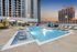 Luxurious rooftop swimming pool with chic cabanas and sun loungers, offering panoramic city views at sunset.