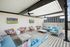 Chic rooftop lounge with comfortable seating, two TVs, and stunning views, perfect for relaxing and entertaining.