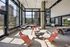 Modern apartment lounge with floor-to-ceiling windows, plush seating, and elegant lighting, offering panoramic city views.