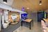 Modern entertainment lounge with stylish decor, featuring a pool table, comfortable seating, and a chic neon sign.