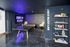 Chic game room featuring a modern ping pong table, neon 'Game On Player' sign, stylish seating, and a bookshelf with games and decor.