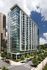 Modern high-rise apartment building with sleek glass facade, offering stunning city views and abundant natural light.