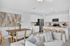 Bright and modern open-concept kitchen and dining area featuring sleek white cabinetry, a stylish dining table, and comfortable seating, perfect for entertaining.