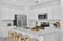 Bright and modern kitchen with sleek white cabinetry, stainless steel appliances, and a stylish island with seating.
