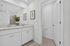 Elegant bathroom with dual sinks, sleek countertops, and modern fixtures, complemented by chic wall art and soft, ambient lighting.