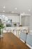 Elegant kitchen with modern white cabinetry, sleek countertops, and a cozy breakfast bar with stylish wooden stools.