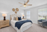 Charming bedroom with natural light, featuring elegant decor, a cozy knit blanket, and stylish modern furniture.