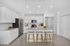 Modern kitchen with sleek white cabinets, stainless steel appliances, and a spacious island with stylish bar stools.