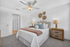 Elegant bedroom with modern decor, featuring a plush bed with pastel pillows, stylish lamps on wooden nightstands, and decorative wall art.