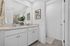Elegant bathroom featuring a double vanity with sleek fixtures, stylish artwork, and abundant natural light for a refreshing ambiance.