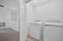 Bright, modern laundry area featuring high-efficiency washer and dryer set in a clean, white space.